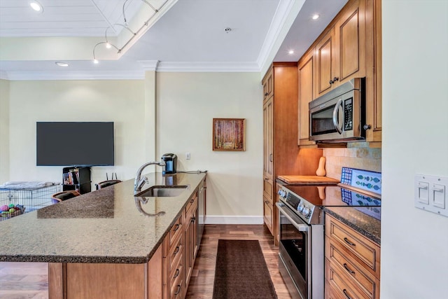 kitchen with dark wood-type flooring, stainless steel appliances, dark stone counters, sink, and backsplash