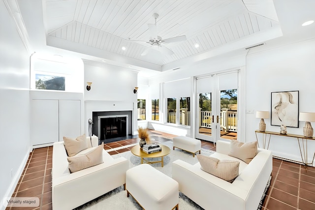 living room with a raised ceiling, a wealth of natural light, dark tile patterned flooring, and wood ceiling