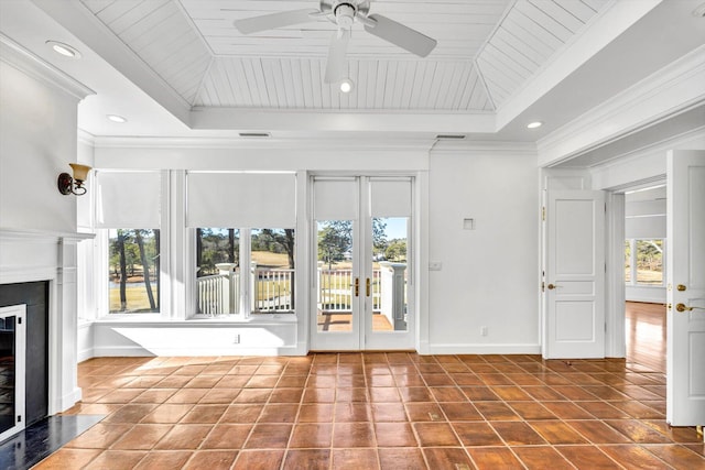 unfurnished living room with crown molding, a healthy amount of sunlight, and a tray ceiling