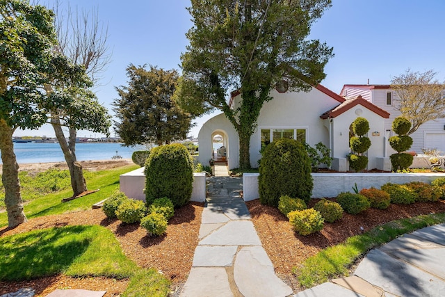 mediterranean / spanish home with a water view and stucco siding