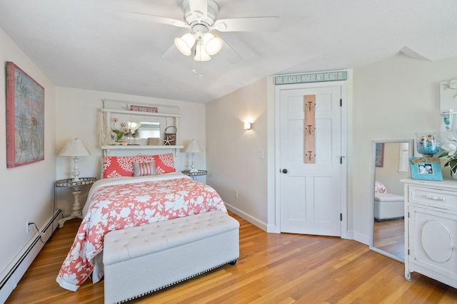bedroom with a baseboard radiator, light wood-style flooring, and ceiling fan