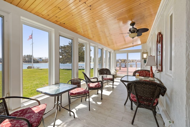 sunroom / solarium featuring a water view and ceiling fan