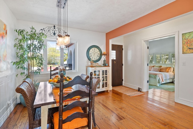 dining room featuring a chandelier, baseboards, and hardwood / wood-style floors