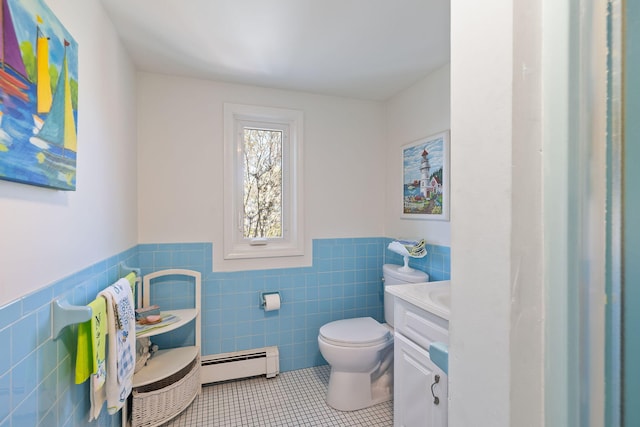 bathroom featuring tile walls, toilet, a baseboard radiator, tile patterned flooring, and wainscoting