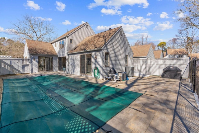 view of pool with central AC, fence, a grill, a fenced in pool, and a patio area