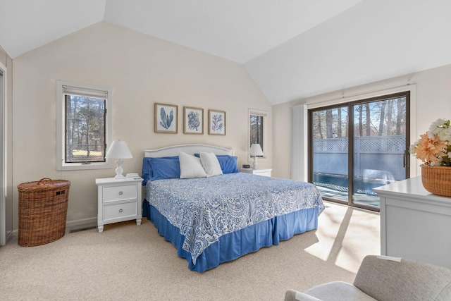 bedroom with access to exterior, light colored carpet, and vaulted ceiling