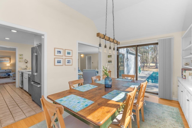 dining space with vaulted ceiling, light wood-style flooring, and recessed lighting