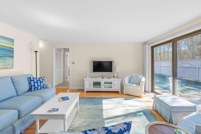 living area with light wood-style flooring and baseboards