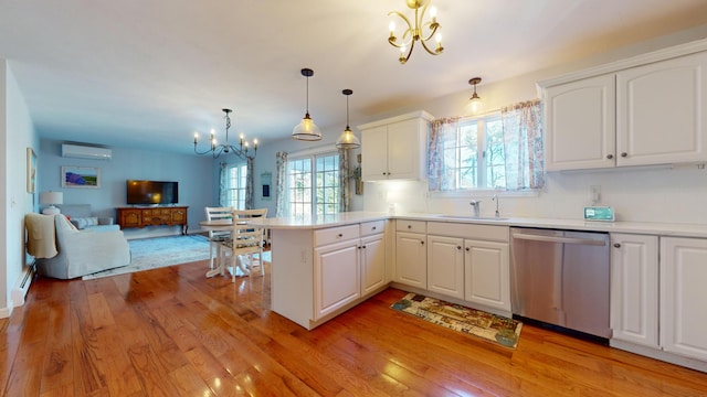 kitchen featuring a chandelier, a wall mounted AC, hanging light fixtures, dishwasher, and kitchen peninsula