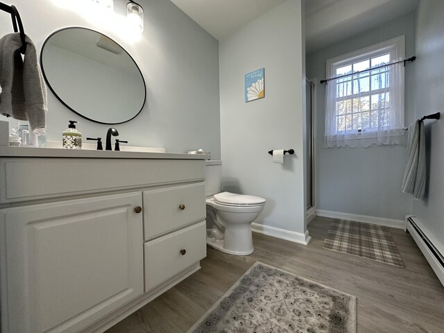 bathroom with toilet, an enclosed shower, a baseboard radiator, vanity, and hardwood / wood-style flooring