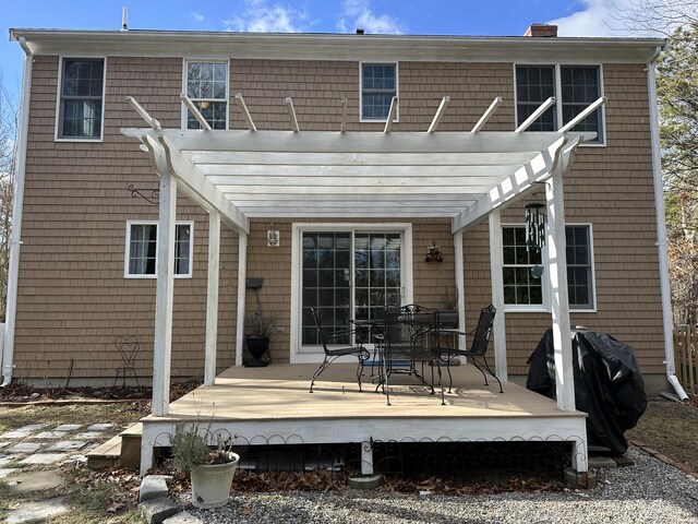 rear view of property featuring a wooden deck and a pergola