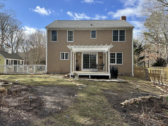 back of house with a pergola, a lawn, and a deck