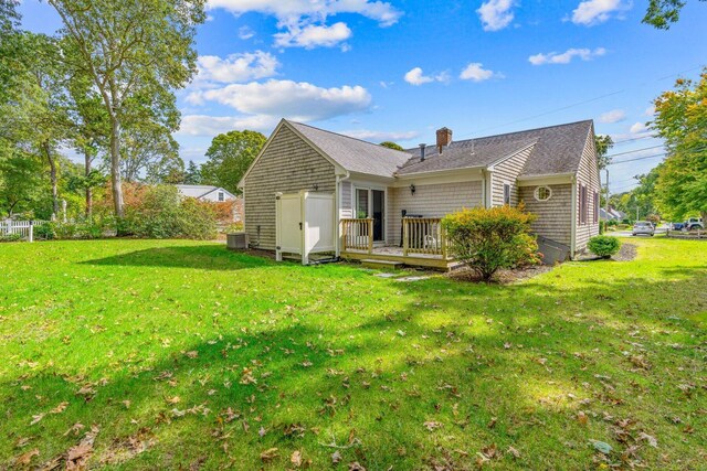 11 Joe Lincoln Rd, West Harwich, MA 02671 - rear view of house featuring cooling unit, fence, a wooden deck, a chimney, and a lawn