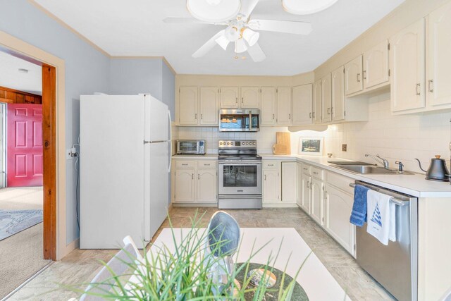 11 Joe Lincoln Rd, West Harwich, MA 02671 - kitchen featuring light countertops, decorative backsplash, stainless steel appliances, a ceiling fan, and a sink