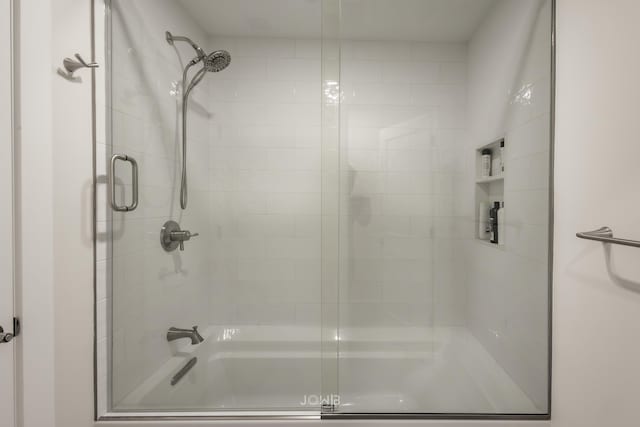 bathroom with shower / bath combination with glass door