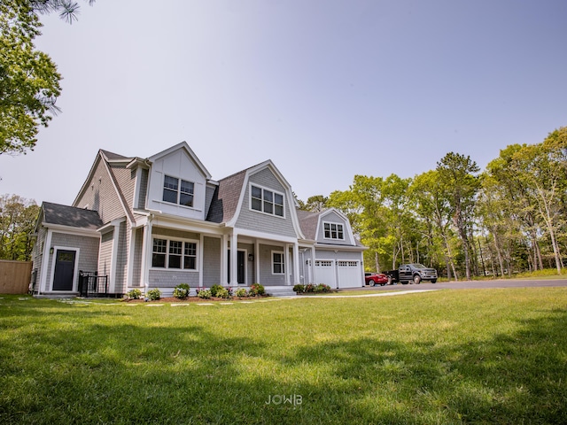 cape cod-style house with covered porch, a front yard, and a garage