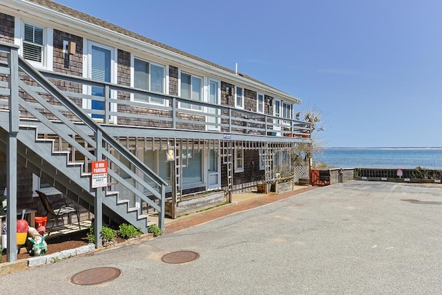 view of building exterior featuring stairway and a water view