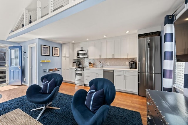 kitchen featuring light wood-style floors, open floor plan, appliances with stainless steel finishes, and recessed lighting