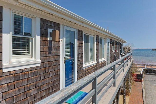 view of property exterior with a water view and a balcony