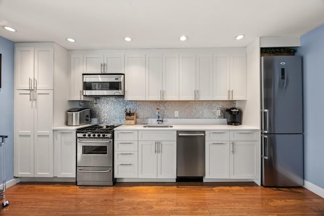 kitchen featuring a sink, appliances with stainless steel finishes, tasteful backsplash, and light countertops