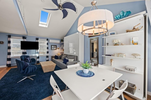 dining room with wood finished floors, lofted ceiling with skylight, and a wall mounted air conditioner