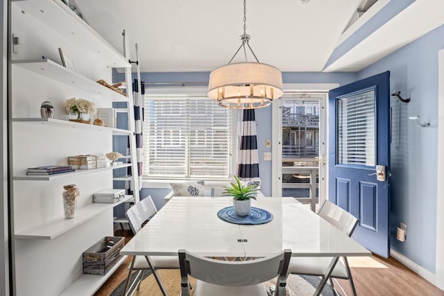 dining room with wood finished floors and a chandelier