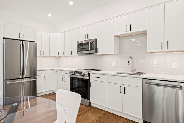 50 Nelson Ave Unit 4, Provincetown, MA 02657 - kitchen with appliances with stainless steel finishes, light countertops, recessed lighting, white cabinets, and wood finished floors