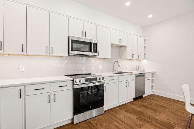 50 Nelson Ave Unit 4, Provincetown, MA 02657 - kitchen featuring appliances with stainless steel finishes, wood finished floors, backsplash, white cabinetry, and light countertops