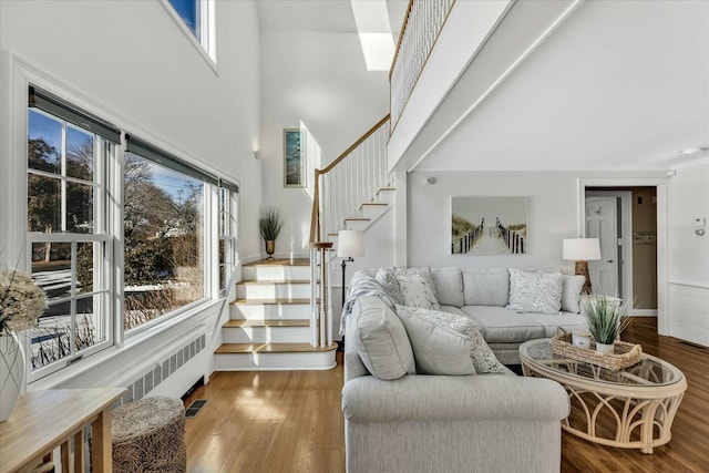 living room with radiator, hardwood / wood-style flooring, and a high ceiling