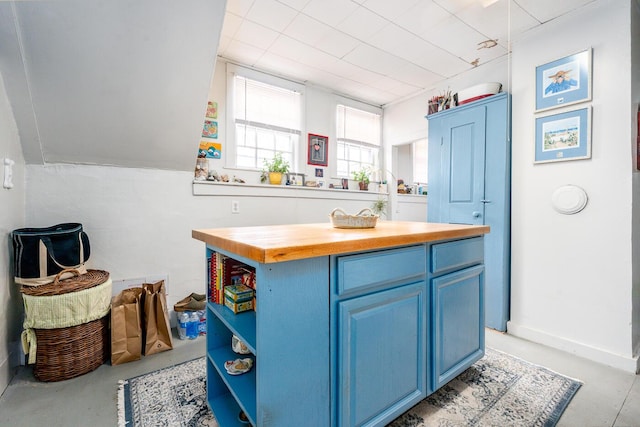 kitchen featuring blue cabinetry, a center island, and butcher block countertops