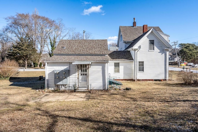 rear view of house featuring a lawn