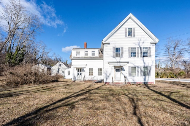 rear view of property featuring a lawn