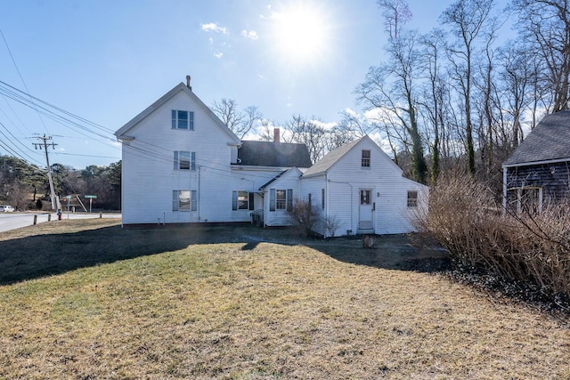 back of house featuring a lawn