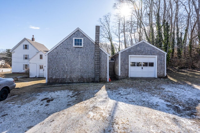 view of front of property featuring a garage and an outbuilding