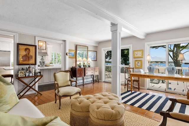 interior space featuring light tile patterned floors, ornamental molding, decorative columns, and a wealth of natural light