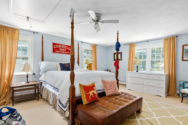 bedroom featuring light carpet, baseboard heating, multiple windows, and attic access