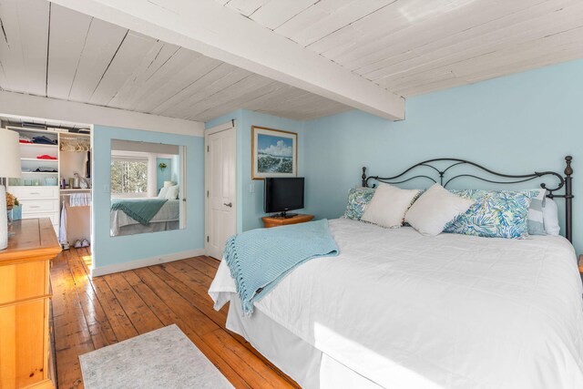 bedroom with baseboards, wood-type flooring, beam ceiling, and wooden ceiling