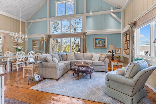 living room featuring hardwood / wood-style floors, an inviting chandelier, and high vaulted ceiling