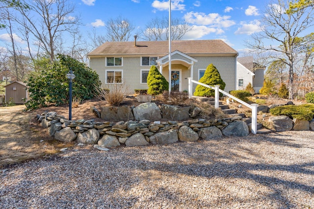 view of front of house featuring an outbuilding and a shed