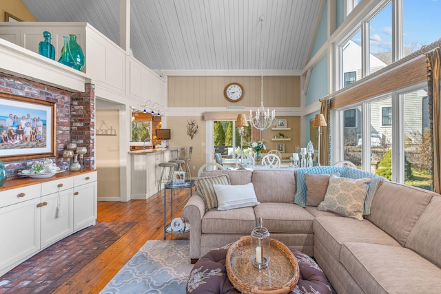 living area with a chandelier, light wood-style flooring, high vaulted ceiling, and a wealth of natural light