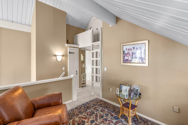 living area featuring baseboards, carpet, and vaulted ceiling with beams