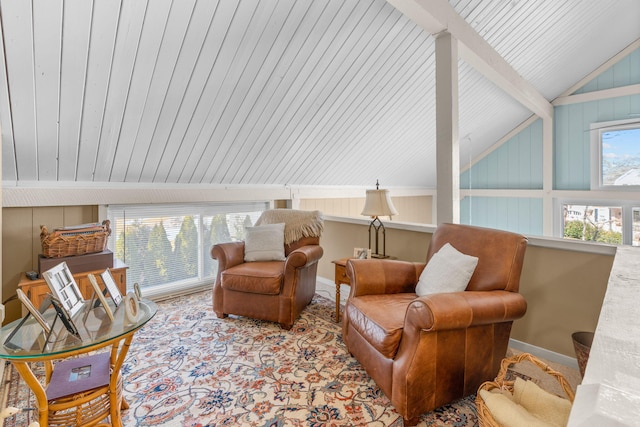 sitting room with vaulted ceiling with beams and baseboards