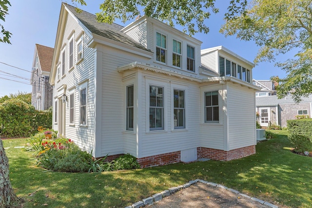 view of home's exterior featuring central AC unit and a yard