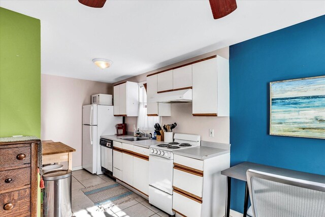 kitchen with white appliances, light tile patterned floors, white cabinets, sink, and ceiling fan