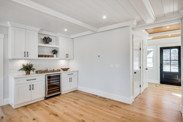 bar with light wood-style floors, wine cooler, and beam ceiling