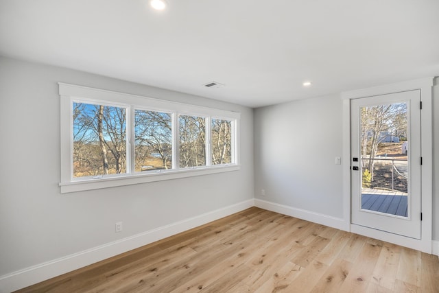 unfurnished room with light wood-type flooring, plenty of natural light, baseboards, and recessed lighting