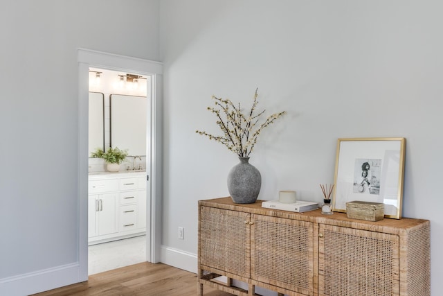 interior space with a sink, baseboards, and wood finished floors