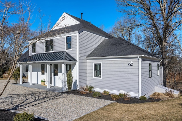 view of front of home featuring a standing seam roof, a porch, metal roof, and roof with shingles