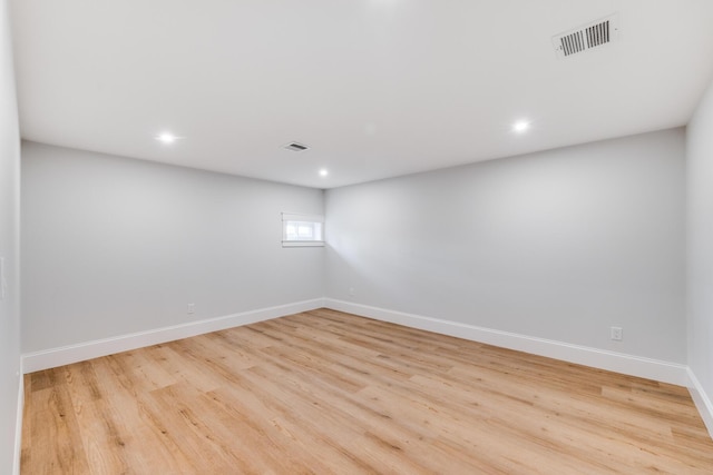 spare room with visible vents, baseboards, and wood finished floors