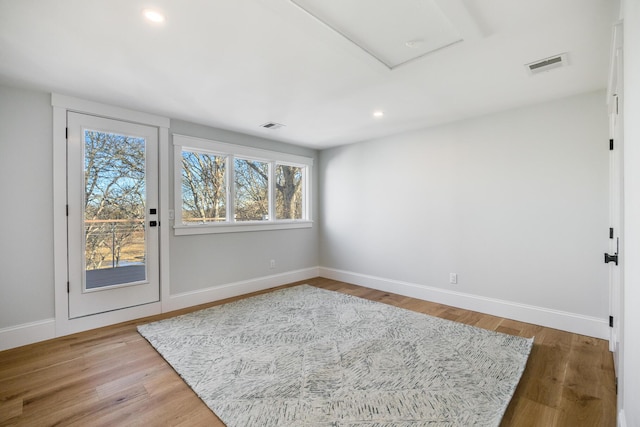 unfurnished room with baseboards, visible vents, wood finished floors, and recessed lighting